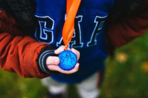 a young boy holding a medal in his hands